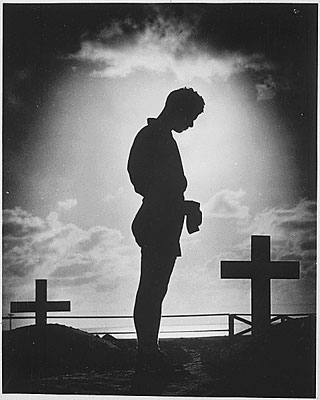 "Silhouetted in the golden glory of a Pacific sunrise, crosses mark the graves of American boys who gave their lives to win a small atoll on the road to the Philippines..."