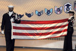 2 Navy members prepare for a flag folding during a retirement ceremony