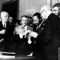 King with President Lyndon Johnson as he signs the Civil Rights Act