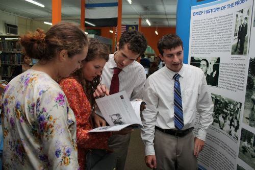 ETAs (from left): Lauren Parsons, Holly Berkley, Peter Culviner, and Owen Cortner reading the Peace Corps Malaysia 50th Anniversary commemorative booklet. (U.S. Embassy photo)