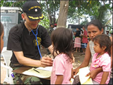 photo of CDR Izune Hwang providing care for children