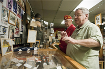 Will Price, a curator for Marine Corps League Detachment 565, talks with Donald Rollette, a fellow detachment member, about the artifacts in the detachment’s 600 square-foot museum, November 16, 2012. Rollette is very active in the community and the Marine league Rollette owns a personal museum as well, which is located in the basement of his home. (U.S. Marine Corps photo by Cpl. Marcin Platek/Released)

