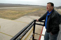 Air Traffic Assistant Billy Summers looks out over the airfield at the newly painted runway and decimated grass Nov. 7 at Sherman Army Airfield. SAAF reopened Nov. 7 to limited operations, daylight hours only as runway lights must be replaced, after being closed since June when three to seven feet of floodwater filled the area.