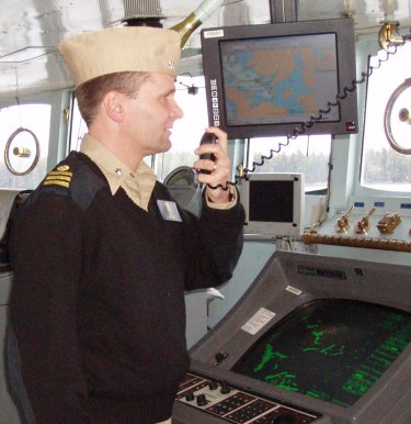 NOAA Corps Officer on bridge of ship using NOAA ENC to assist in navigation.