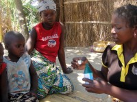 Community health worker Rosalina Casimiro meets with children in Nampula province, Mozambique, to demonstrate how to purify water prior to drinking. Photo credit: Luisa Chadreque, Pathfinder Nampula