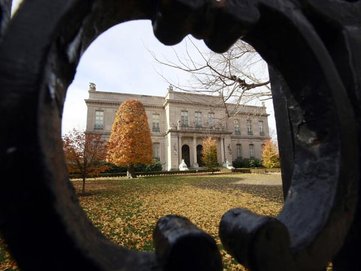 FILE - This Nov. 19, 2010 file photo shows the Elms mansion as seen through an opening in an iron fence, in Newport, R.I.  Newly discovered photographs, documents and family histories have inspired the creation of a tour about servants at The Elms, echoing themes of the British drama program, "Downton Abbey." (AP Photo/Steven Senne, File)