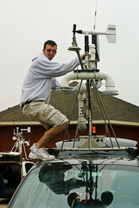 NSSL researcher adjusts the equipment on a mobile mesonet vehicle in the field