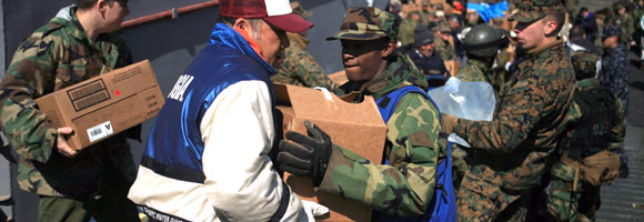 Service members moving disaster relief boxes