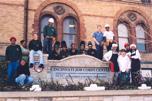 Several students standing next to the center sign