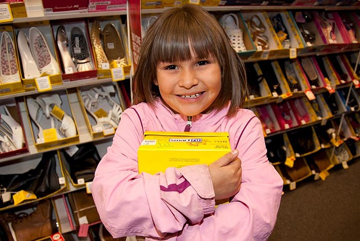 A young student receives a new pair of shoes thanks to the generosity of LANL employees, through the LANL Laces Program