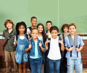 Children standing with backpacks on