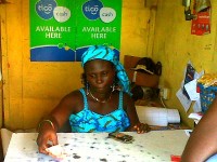 A woman sells prepaid mobile phone airtime credits. Photo Credit: Devex.