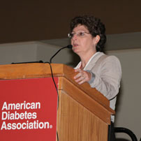 Allison B. Goldfine, M.D., head of the Section of Clinical Research at Joslin Diabetes Center and an associate professor of medicine at Harvard Medical School, speaks on “Uncovering New Therapeutic Approaches for Type II Diabetes Through Bariatric Surgery Research” during an NIDDK symposium on “Novel Pathways to Treatment of Type 2 Diabetes and Obesity” on June 26, 2010, part of the American Diabetes Association’s Scientific Sessions in Orlando.  Goldfine wears a tan jacket and has short curly hair.  She speaks at a wooden podium with a red “American Diabetes Association” sign on it.