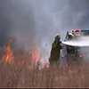 Firefighters battling a grass fire