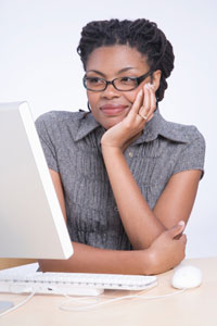 Photograph of a woman looking at a laptop computer.