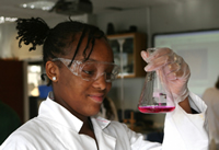 A female student completing a science experiment; iStock.com