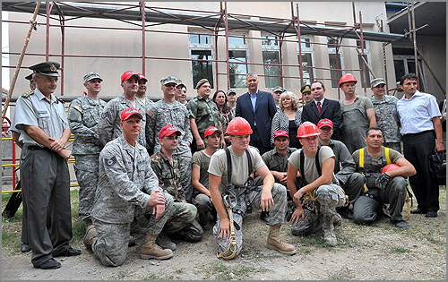 A group of men in military uniform posing at a construction site