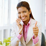 Photograph of a young person talking on the phone and giving the thumbs up gesture.