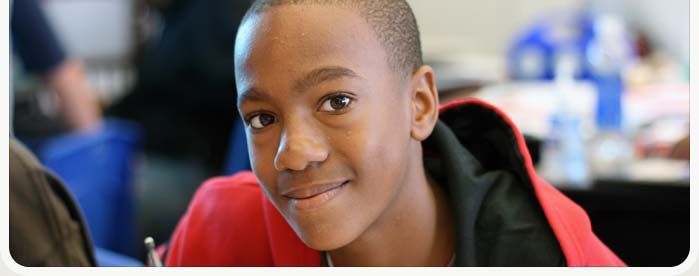 Close up of smiling, African American boy in red sweatshirt