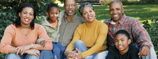 A family sits together in the grass.