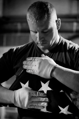 Lance Cpl. Bradley Young, a Marine Corps body bearer, finishes folding a funeral flag during a practice funeral