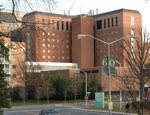 A green banner commemorating NIDDK’s  anniversary with a large printed “60 years” hangs on a lamp post in front of the NIH Clinical Research Center