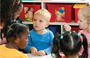 A teacher is teaching a group of young children in a classroom