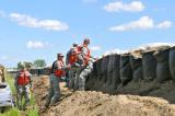 Spc. Sandra Dewey passes a sandbag to Spc. Krista Dahl given to her by Sgt. Michael Beechie. The Soldiers are quick response force reinforcing the levee on 48th Ave south of Bismarck. (Photo by Sgt. Jesica Geffre, 116th Public Affairs Detachment)