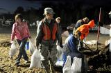 2nd Lt. Renee Connor, 3662nd Maintenance Company, assists in loading sandbags onto a civilian volunteer's truck during the nightshift of flood duty in Bismarck. 