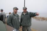 Lt. Col. Nate Erstad listens to Capt. Grant Larson as he points to a road washed out near a home in rural Argusville, N.D., April 9. Both serve as liaison officers in the Cass County tactical operations center. (Photo by Senior Master Sgt. David H. Lipp)