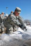 Spc. Austin Ackerman, of Jamestown, begins the sandbagging line at a home southwest of West Fargo April 12, 2011. A 12-man North Dakota National Guard quick reaction force team quickly created a dike around the home. (Photo by Spc. Jess Raasch) 