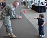 Staff Sgt. Trevor Derosier plays catch with his son Bristen at the Alerus Center in Grand Forks before the 1st Battalion, 188th Air Defense Artillery Regiment’s Freedom Salute 