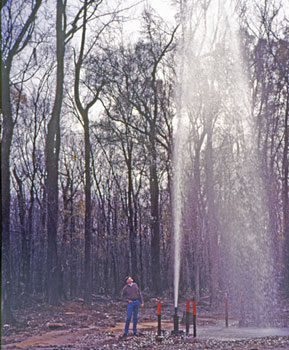 Picture of a well flowing water under artesian pressure. Underground pressure forces water to the surface.