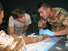 SGT Tammy Ellis supervises a Romanian soldier during combat lifesaver training.