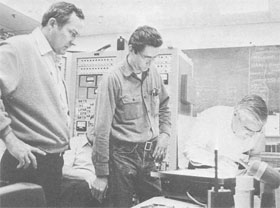 (L-R) R. Huson, G. Mulholland, and W. Fowler search film for tracks