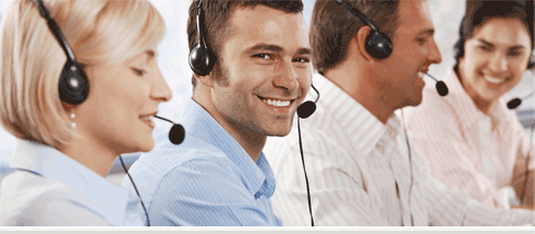 Four individuals wearing headsets in a call center.