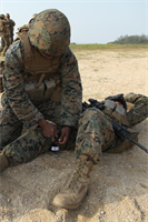A Marine applies a tourniquet to a simulated casualty during 3rd Supply Battalion’s supply management unit exercise Jan. 25 at Kin Blue Training Area near Camp Hansen. 
