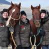 Three BLM public information officers posing for a photo with two Prada horses.