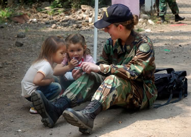 LT Elizabeth Leavitt, a health services officer, takes a break to enjoy a moment with local El Salvadoran kids.