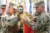 Col. Brian Tempest, commander, 1st Sust. Bde., left, and Command Sgt. Maj. Virgil McCloud, brigade senior NCO, right, unfurl the unit’s colors at Bagram Airfield, Afghanistan, as the unit assumes control over sustainment operations in Regional Command - East, North and Capital.  Photo by: Capt. Kymberly Koenig, 1ST SUST. BDE.