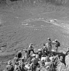 Shoemaker lecturing to astronaut group on rim crest of Meteor Crater during field trip 16-19 May 1967; USGS photo P324, F56773PR.