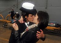 Fire Controlman 2nd Class Marissa Gaeta, left, assigned to the amphibious dock landing ship USS Oak Hill (LSD 51) kisses her fiancée, Fire Controlman 3rd Class Citlalic Snell.