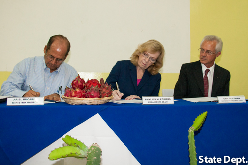 Embajadora Powers firmando acuerdo junto a Ariel Bucardo a su derecha quien también firma