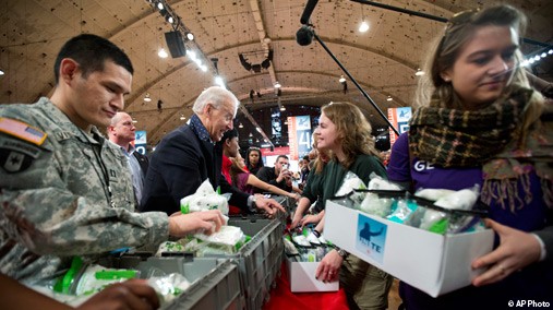 Vice President Joe Biden, center, works with volunteers, filling care kits with necessities for deployed U.S. service members, wounded warriors, veterans and first responders, joining the National Day of Service as part of the 57th presidential inauguration in Washington, January 19, 2013. Army Capt. Cesar J. Visurraga, US Army Nurse Corps, is at left. [AP Photo]