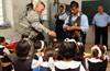 KIRKUK, Iraq (October 5, 2006) - U.S. Army Staff Sgt. Shawn Smith (left) hands out school supplies to students with the help of Iraqi police officers during a visit to an elementary school in Kirkuk, Iraq, on Sept. 27, 2006. Smith is assigned as a platoon leader with Bravo Company, 2nd Battalion, 35th Infantry Regiment, 25th Infantry Division. Photo by Master Sgt. Steve Cline, U.S. Air Force.