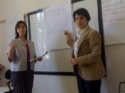 Two women stadning in front of a white board