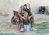 WEST OF ASR SIOUX, Iraq (October 7, 2006) - An Iraqi army soldier hugs an Iraqi child as fellow soldiers inspect his family's house in a village west of Alternate Supply Route Sioux in Iraq Sept. 28, 2006. Photo by Spc. Billy Brothers, U.S. Army.