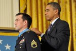 President Barack Obama placed the Medal of Honor around the neck of former Army Staff...