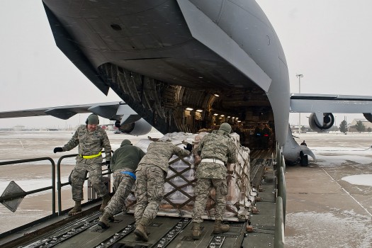 Airmen assigned to the 97th Logistics Readiness Squadron push a pallet loaded with food into the back of a C-17 Globemaster III on Altus Air Force Base, Okla., Dec. 28, 2012. After loading 137,000 pounds of beans and rice, members of the 58th Airlift Squadron transported the food to Port-au-Prince, Haiti, in support of the Denton Amendment, a program that provides relief to Haitian citizens by making the transportation of humanitarian aid possible. U.S. Air Force photo by Airman 1st Class Levin Boland