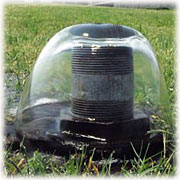 Picture of a small well uncapped showing artesian groundwater flowing freely from it, without the use of a pump.